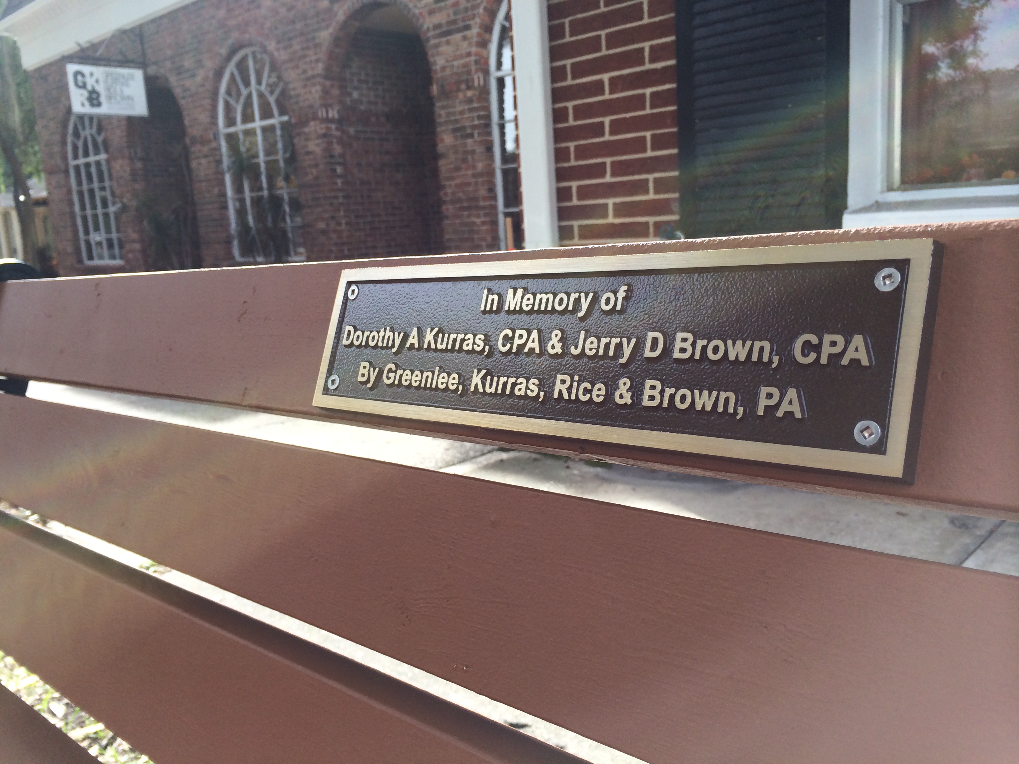 New park bench next to office in memory of firm principals Dottie Kurras CPA (1937-2010) & Jerry Brown CPA (1950-2013)